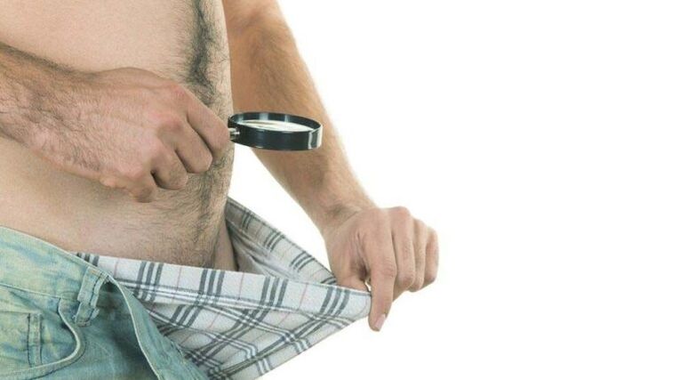 seorang pria melihat ke dalam celana dalamnya dan berpikir tentang pembesaran penis dengan soda